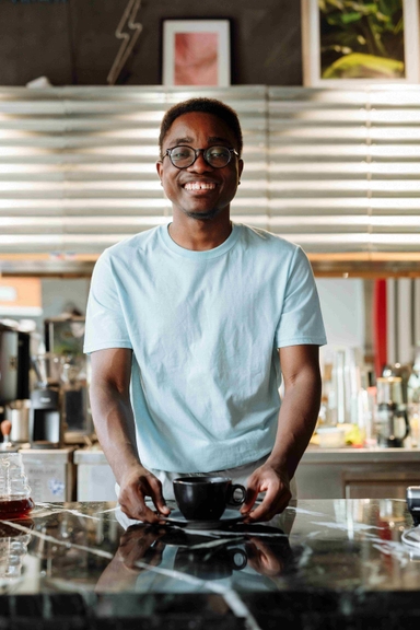 Specialty coffee being poured out of a carafe into a coffee cup.